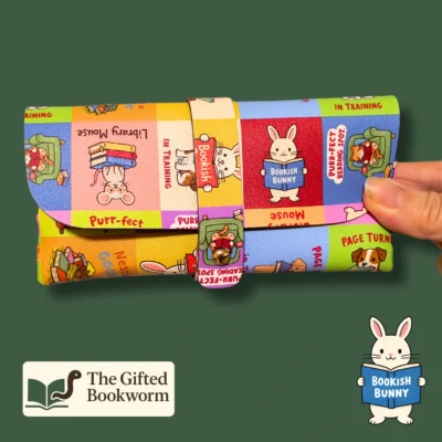 Colorful bookish glasses case with literary puns and reading animal illustrations, featuring secure snap closure